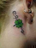 A pretty four leaf clover tattoo on the back of a girl's neck, behind the ear.