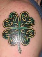 An intricate four leaf clover shoulder tattoo
