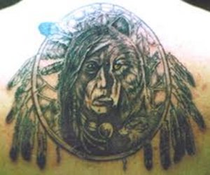Tattoo of the head of a skin walker enclosed within a dream catcher