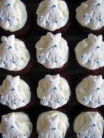 This is an image of cupcakes with wedding dresses on them