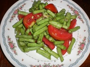 This is an image of a string bean salad with tomatoes