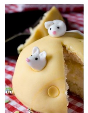 This is a cake that was made to look like a hunk of cheese with mice in it