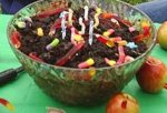 This is an image of worms in dirt cake. It is cake that has been broken up and mixed with chocolate pudding and Oreo cookies. Then gummy worms put into it.
