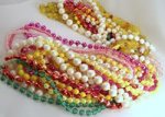 Several different necklaces of different colors made of plastic beads strung together