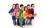This is an image of a bunch of children holding up a safety sign.